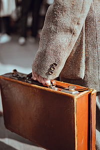 person holding brown leather briefcase taken at daytime thumbnail