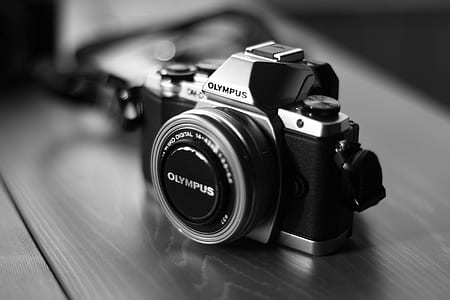 black and gray Olympus MILC camera on brown surface thumbnail