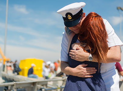 woman captain hugging woman in blue and white polka-dot dress thumbnail
