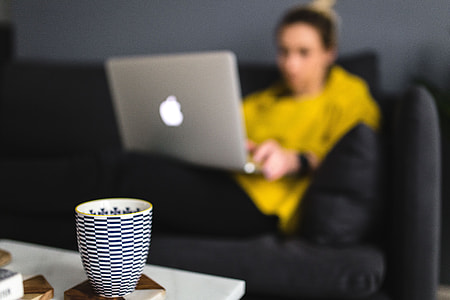 Young woman sitting on the sofa and working on her laptop thumbnail