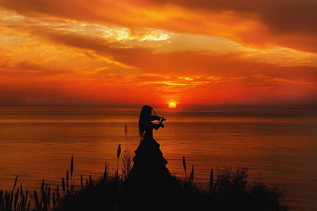 woman playing violin beside water thumbnail