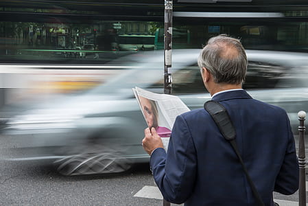 man holding magazine while crossing street thumbnail