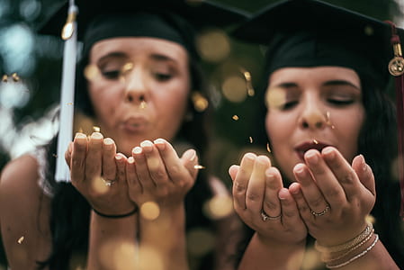 two women blowing leaf from their hands thumbnail