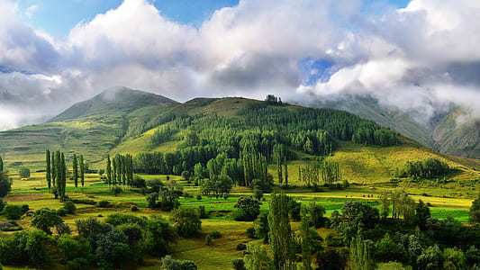 green mountain near trees under blue sky during daytime thumbnail