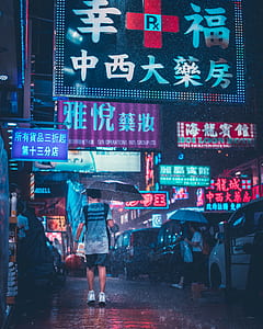 man holding umbrella during rainy nighttime lapse photo thumbnail