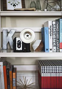 black and white instant camera on white wooden shelf thumbnail