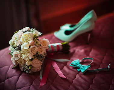 white and pink rose boquet beside teal bow tie and pair or white pumps thumbnail