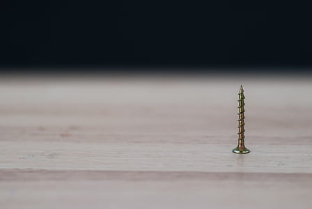 Close-up Photography of a Brass Colored Screw on Top of the Table thumbnail