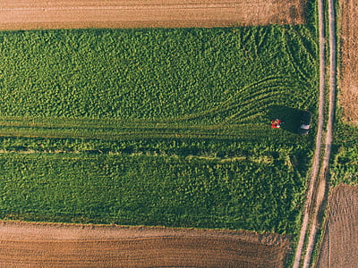 aerial photography of gray vehicle on green field at daytime thumbnail