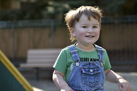 smiling boy wearing green and blue top during daytime thumbnail