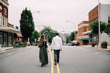 man and woman walking on road during daytime thumbnail
