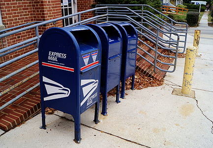 three blue metal garbage bins near grey metal rail thumbnail