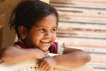 focus photography of girl leaning on plastic chair smiling thumbnail
