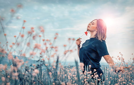 woman holding poppy flower at flower field thumbnail