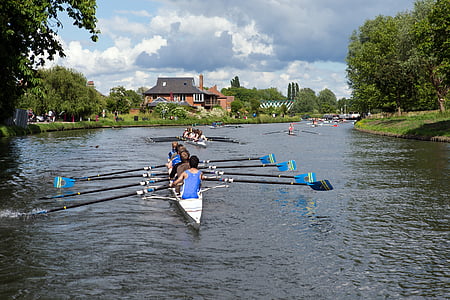 people paddling boat in body of water in between trees thumbnail