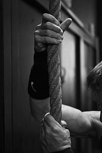 grayscale photo of person holding rope thumbnail