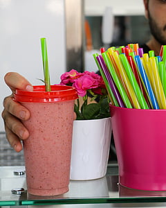 person holding red disposable cup with green straw thumbnail