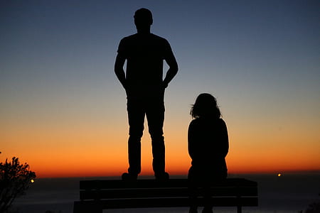 silhouette of standing man beside sitting woman thumbnail