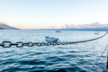selective focus photography of chain rope near body of water thumbnail