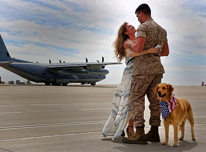 golden retriever standing next to woman and man hugging thumbnail