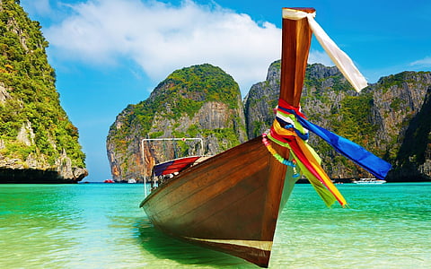 brown wooden boat on clear water under blue sky thumbnail