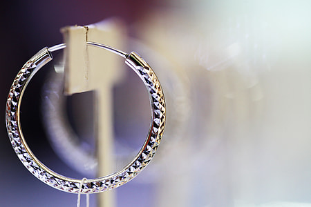 selective focus photo of silver-colored hoop earring thumbnail
