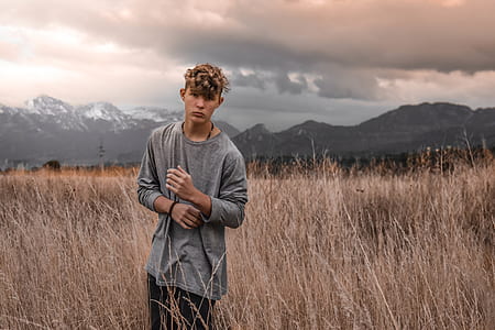 man wearing gray long-sleeved shirt between wheat field thumbnail