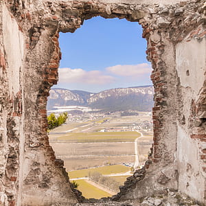 brown and gray concrete wall viewing aerial photography of fields with buildings under white cloud blue skies thumbnail