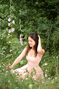 woman in peach dress sitting on flower garden thumbnail