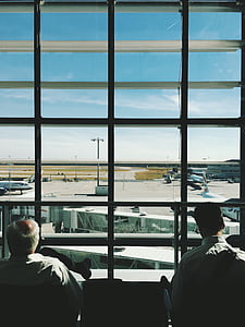 two person looking through window in airport thumbnail