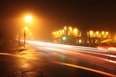 time lapse photography of passing cars on road near building during nighttime thumbnail