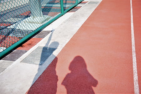 two person silhouettes near green metal fence thumbnail