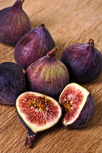 shallow focus photo of purple figs on brown wooden surface thumbnail