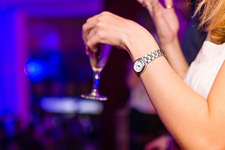 woman wearing white sleeveless top holding clear drinking glass thumbnail