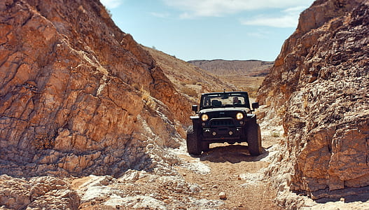 black Jeep Wrangler SUV between rock formation thumbnail