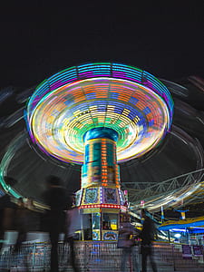 people walking near multicolored amusement park ride at daytime thumbnail