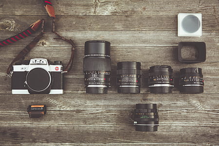 Black and Gray Dslr Camera With Assorted Lenses on Brown Wooden Surface thumbnail