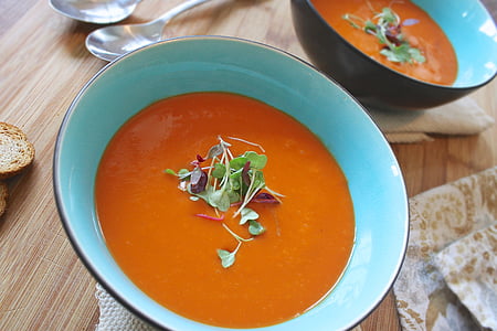 soup with green leaves in teal ceramic bowl thumbnail