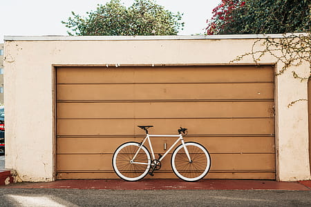 white road bike parked outside garage thumbnail
