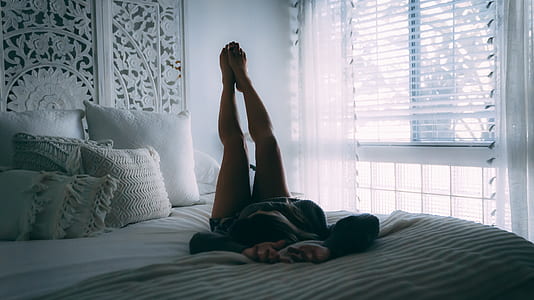 person lying on bed while raising feet thumbnail