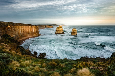 bird's eye view body of water crashing on rock during golden hour thumbnail