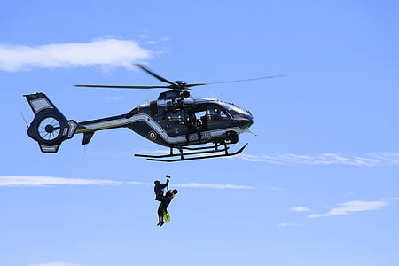 two person hung under helicopter during daytime thumbnail
