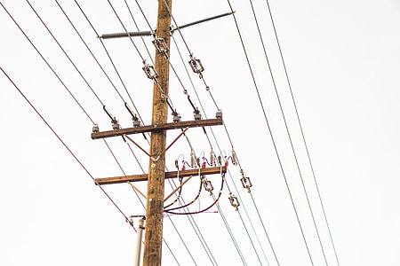 low angle photo of brown electric post under white sky thumbnail