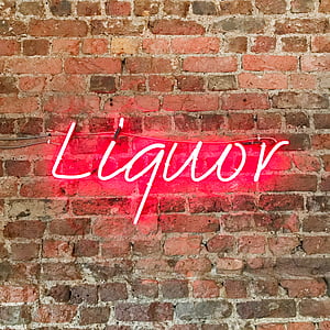 lit red liquor neon signage on brick wall thumbnail