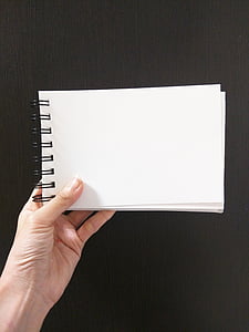 person holding white spiral notebook thumbnail