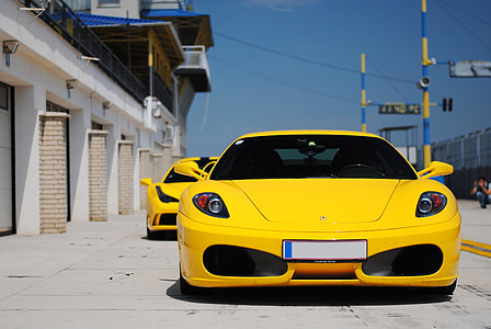 yellow Ferrari sports car on road during daytime thumbnail