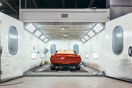 orange car inside a well-lighted open garage thumbnail