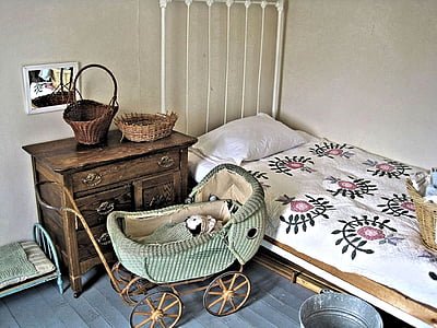 green travel bassinet near cabinet and bed inside room thumbnail