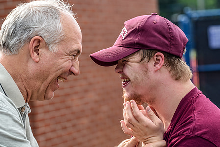 depth of field photography of man in gray shirt near the boy in maroon cap thumbnail