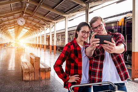 Man and Woman Taking Selfie Near Gray Train thumbnail